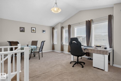 Expansive open-concept room featuring vaulted ceilings, light neutral wall tones, and carpet flooring - 7858 170A Avenue, Edmonton, AB 