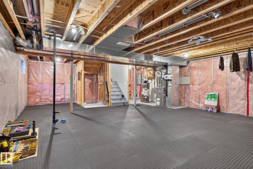 Expansive unfinished basement featuring a partially insulated perimeter, exposed wood joists, and utility access - 7858 170A Avenue, Edmonton, AB 