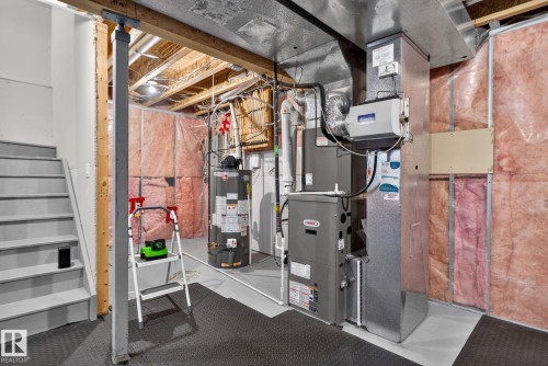 Utility area featuring a water heater, furnace system, and exposed ceiling joists - 7858 170A Avenue, Edmonton, AB 