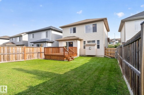 Expansive green lawn with a wood-plank deck featuring wood railings and lattice skirting - 7858 170A Avenue, Edmonton, AB 