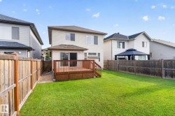 Expansive backyard featuring a manicured lawn, full wood fencing, and a private wooden deck - 