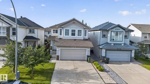 Two-story residence featuring light gray siding, a two-car garage, and a concrete driveway - 7858 170A Avenue, Edmonton, AB 