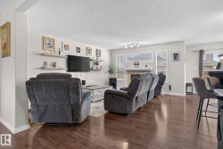 Spacious living area featuring rich wood-finish flooring - 