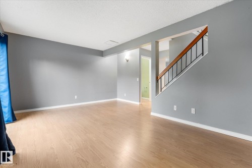 Spacious room featuring wood-finish flooring, light gray wall tones, and white trim - Fort Saskatchewan, AB 