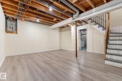 Finished basement space featuring light wood-finish flooring, recessed lighting, and painted walls - 