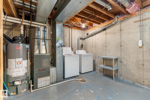 Utility area featuring a water heater, furnace, and exposed ceiling joists - Fort Saskatchewan, AB 