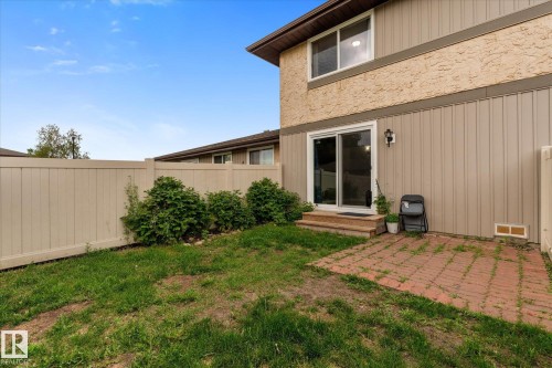 Private backyard featuring a paneled fence, established shrubs, and a paver patio - Fort Saskatchewan, AB 