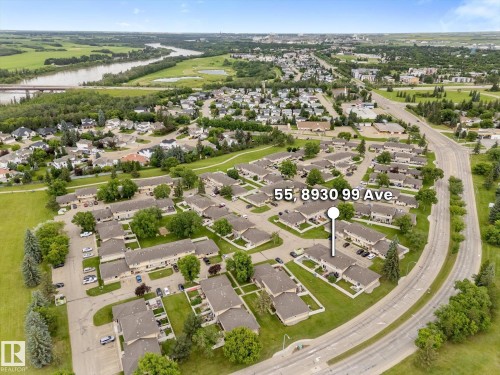 Aerial overview of a residential complex featuring multiple attached homes with light-colored siding and dark roofs - Fort Saskatchewan, AB 