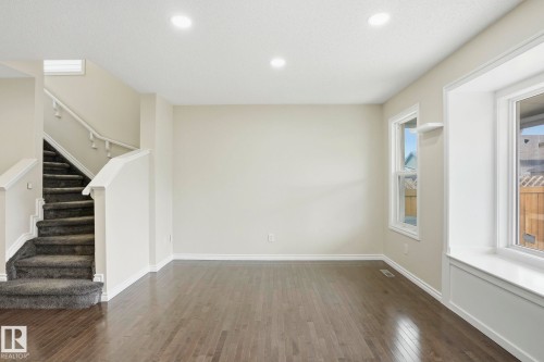 Spacious room featuring wood-finish flooring, light-toned walls, and recessed lighting - 445 Watt Boulevard, Edmonton, AB 