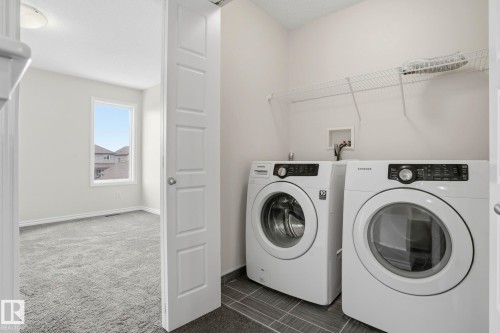 Dedicated laundry area featuring dark tile flooring and a white wire shelving unit - 445 Watt Boulevard, Edmonton, AB 