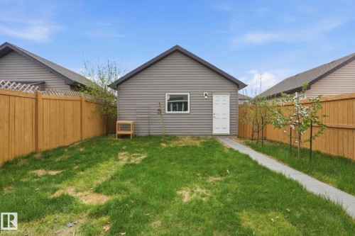 Detached garage with horizontal siding and a white entry door - 445 Watt Boulevard, Edmonton, AB 