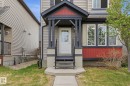 Inviting front entrance featuring a covered porch with dark trim and red accents - 445 Watt Boulevard, Edmonton, AB 