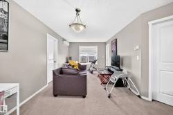 Carpeted living space with neutral painted walls and a textured ceiling - 