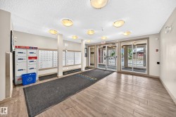 Building entrance featuring wood-finish flooring and multiple flush-mount light fixtures - 