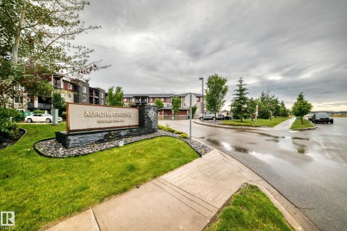 Entry sign for Aurora Greens featuring stone accents and landscaping - 417 1510 Watt Drive, Edmonton, AB 