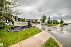 Entry sign for Aurora Greens featuring stone accents and landscaping - 