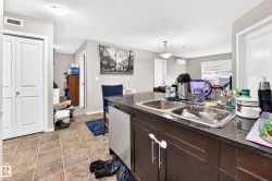 Kitchen island with a double basin stainless steel sink and dark countertop - 