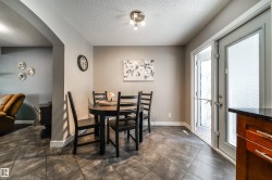 Kitchenette featuring dark gray tile flooring, a white exterior door with glass panels, and a stainless steel ceiling light fixture - 