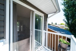 Private balcony featuring white railings and a sliding glass door - 