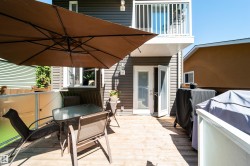 Spacious wood-plank deck featuring direct access via double French doors and a balcony overhead - 