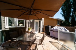 Expansive wooden deck featuring horizontal siding, a glass-paneled door, and a privacy fence - 