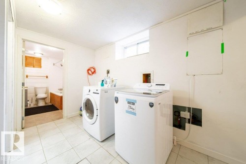 Dedicated laundry area featuring white tile flooring and a compact window - 4224 89 Street, Edmonton, AB 