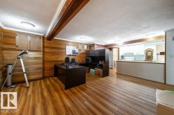 Open-concept space featuring wood-finish flooring, paneled walls, and built-in cabinetry - 