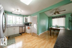 Kitchen featuring light wood-finish flooring, white cabinetry, and stainless steel appliances - 
