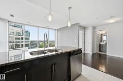Kitchen island featuring a double basin stainless steel sink, gooseneck faucet, and granite countertop - 