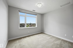 Room featuring a large window, textured carpeting, light gray wall paint, white baseboards, and a ceiling-mounted light fixture - 