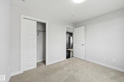 Neutral-toned carpeted room featuring a ceiling light fixture, white trim, and light gray walls - 