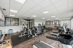 Fitness center featuring wood-finish flooring and extensive mirrored walls - 