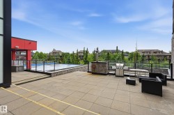 Expansive tiled patio featuring a built-in stone grilling station - 