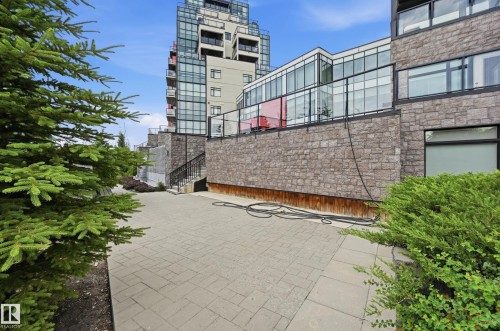 Paved patio area featuring stone retaining walls and perimeter landscaping - 528 5151 Windermere Boulevard, Edmonton, AB 