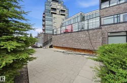 Paved patio area featuring stone retaining walls and perimeter landscaping - 