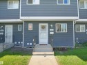Townhome exterior featuring gray horizontal siding and white trim - 575 Dunluce Road, Edmonton, AB 