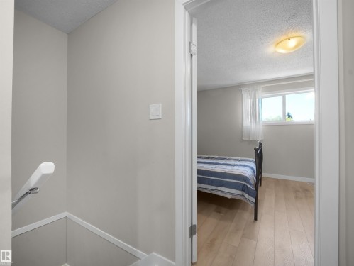 Room featuring wood-finish flooring, a window with natural light, and a ceiling-mounted light fixture - 575 Dunluce Road, Edmonton, AB 