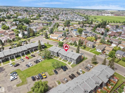Aerial perspective highlighting two-story townhomes with gray exteriors and shingled roofs - 575 Dunluce Road, Edmonton, AB 