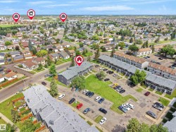 Aerial perspective showcasing a residential community with various housing types, including multi-unit buildings with shingle roofs - 