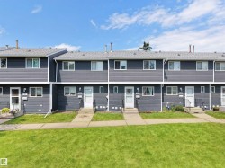 Row of townhomes featuring charcoal grey siding and white trim - 