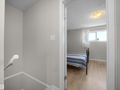 Room featuring wood-finish flooring, a window with natural light, and a ceiling-mounted light fixture - 