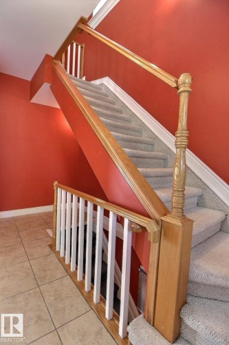 Carpeted staircase with light wood-finish railings and white balusters - 11312 127 Street, Edmonton, AB 