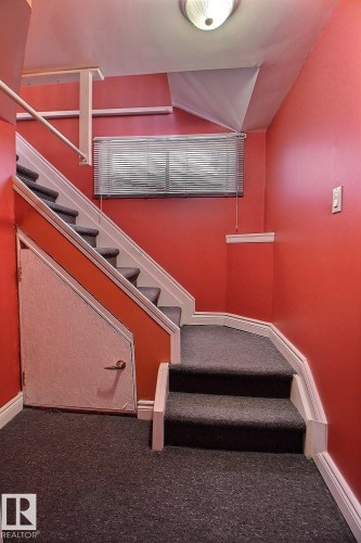 Staircase featuring dark gray carpeted steps and white risers - 11312 127 Street, Edmonton, AB 