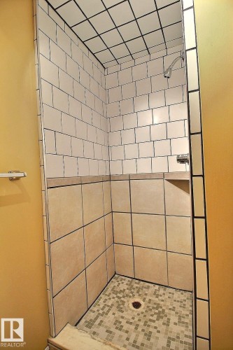 Shower with subway tile walls, a built-in corner shelf, and mosaic tile flooring - 11312 127 Street, Edmonton, AB 