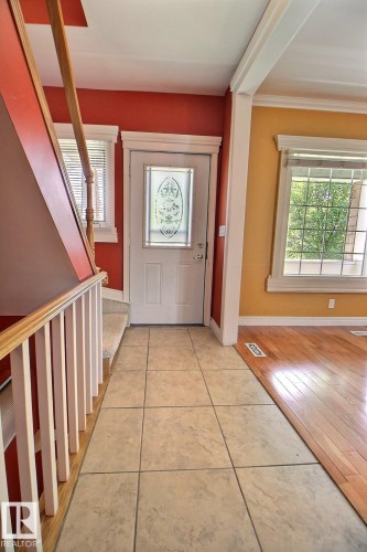 Entryway featuring light-toned tile flooring and a decorative glass-paneled door - 11312 127 Street, Edmonton, AB 