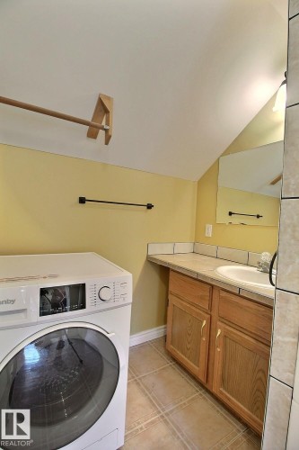 Dedicated laundry area featuring a front-loading appliance - 11312 127 Street, Edmonton, AB 