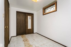 Room featuring white walls, patterned floor tiles, a window with security bars, and a sliding closet door with a full-length mirror - 