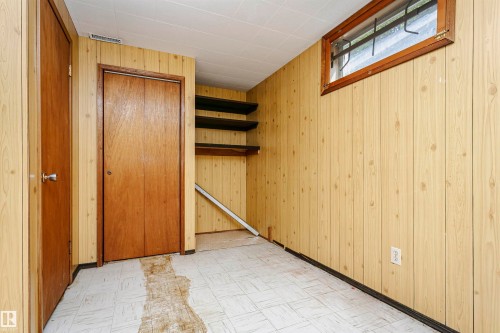 Room featuring wood-paneled walls, a window with wood trim, and a drop ceiling - 11440 44A Avenue, Edmonton, AB 