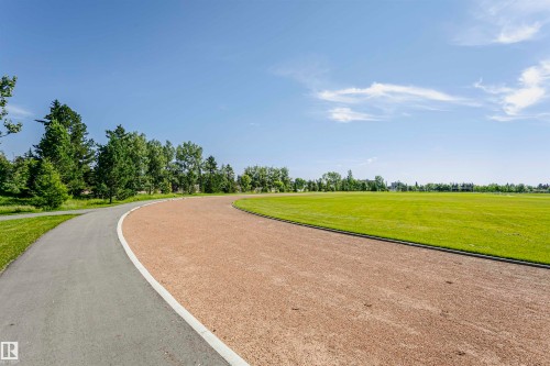 Curved asphalt pathway bordering a large, open green field - 11440 44A Avenue, Edmonton, AB 