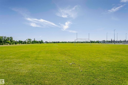 Expansive athletic field with manicured green grass, featuring a set of goalposts and perimeter lighting - 11440 44A Avenue, Edmonton, AB 